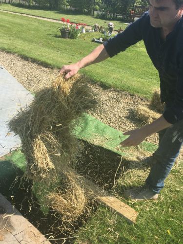 adding hay to grave