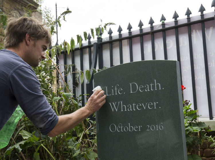 cleaning headstone at Sutton House
