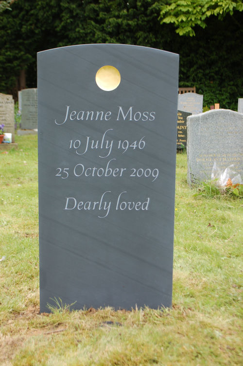 slate headstone with gold disc at top